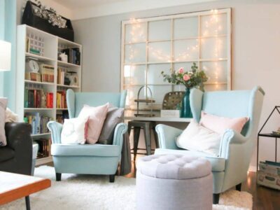 living room with blue chairs and fairy lights on the wall